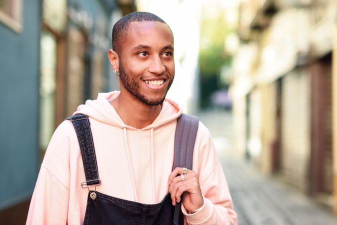 Male looking up while happily smiling on outdoor street
