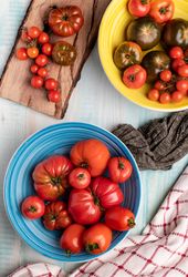 Napkins near bowls and board with tomatoes