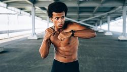 Athletic Black male practicing boxing during training