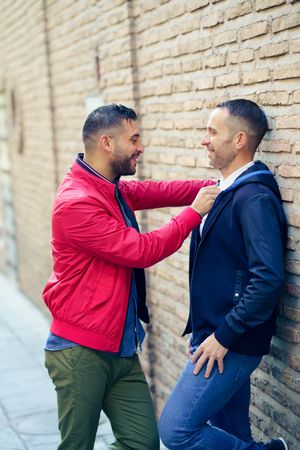 Side view of gay couple in a romantic moment on the street, vertical