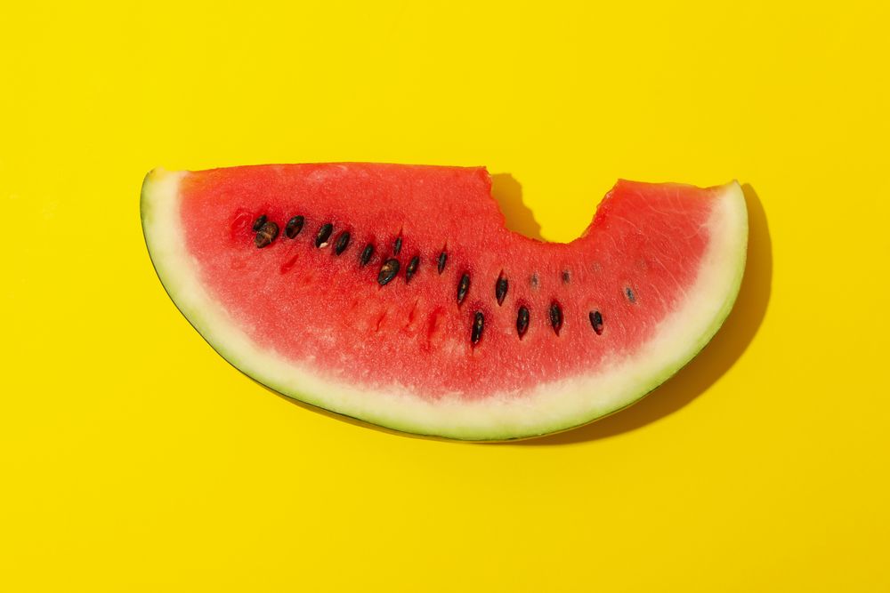 Fresh watermelon slice on yellow background. Summer fruit