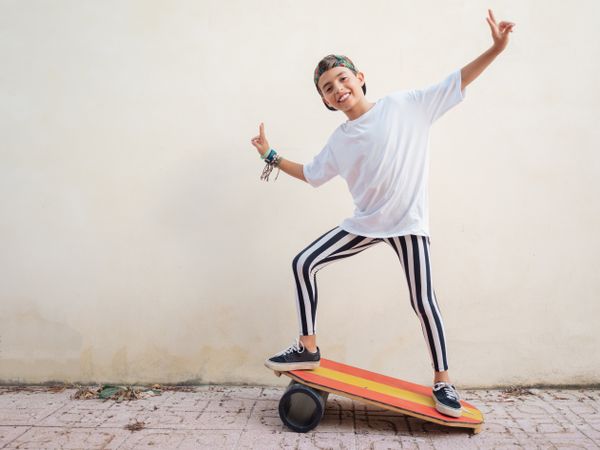 Cheeky boy standing on colorful board and swinging