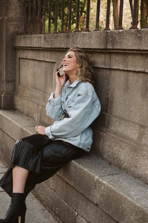 Woman using smartphone near park fence