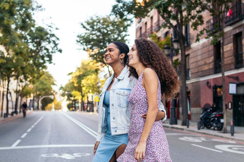 Lesbian couple walking down the street, holding hands.