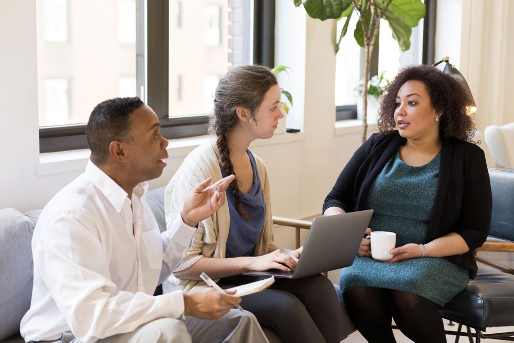 Three employees discussing a strategy in a business meeting