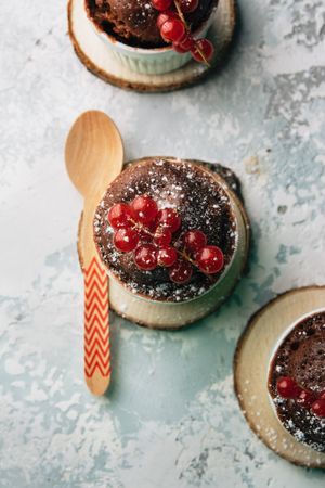 Three Chocolate cakes in the cup with currants and sugar glass.