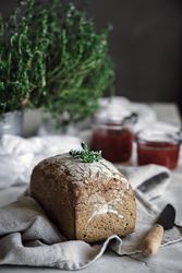 Fresh bread on napkin near tomatoes jam