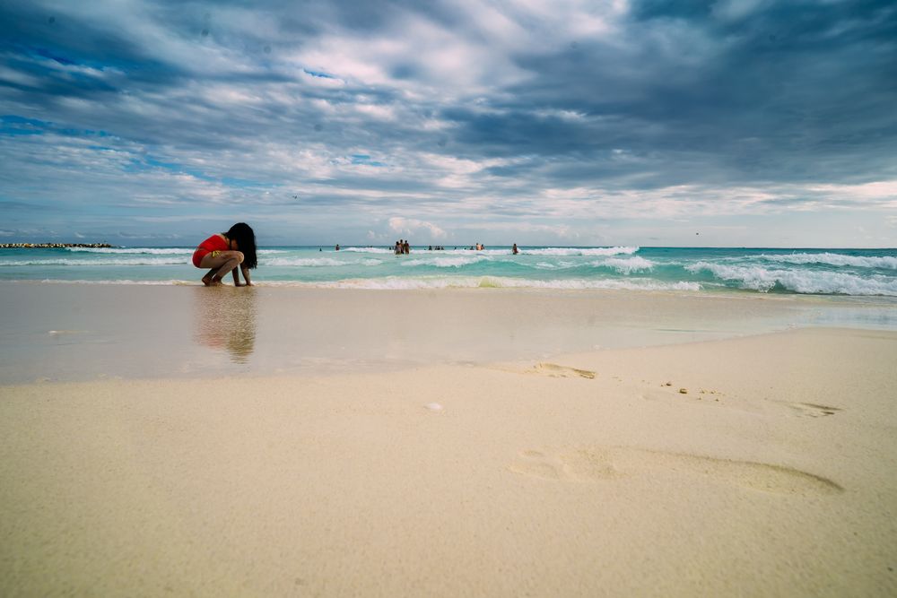 Girl in swimsuit playing on beach