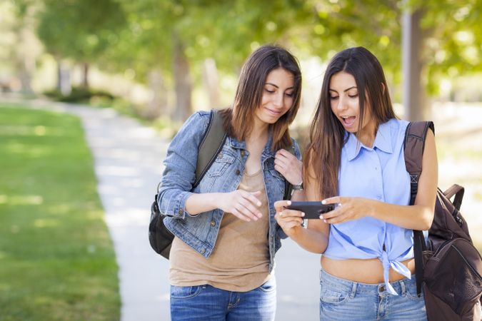 Twin Sisters Looking Over Cell Phone