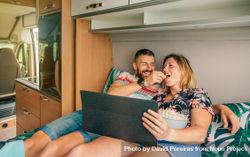 Male and female eating popcorn and watching a movie on a motorhome bed 41E9j4