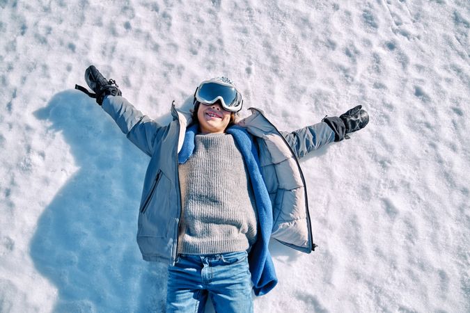 Cheerful boy lying on snow