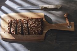 Sliced wholegrain bread on wooden cutting board