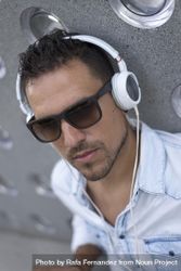 Man relaxing outside while listening using headphones 0WWyM0