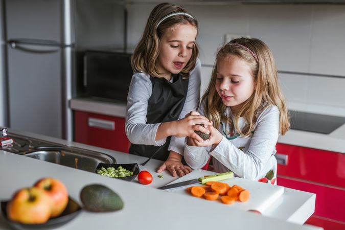 Little girl showing cut avocado
