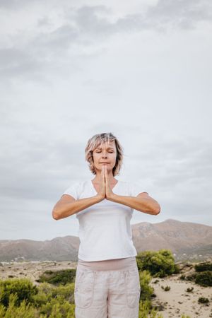 Barefoot woman meditating on stone