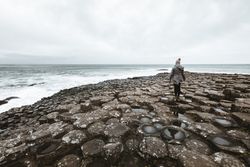 Female standing on cliff and contemplating