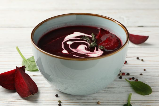 Bowl of borscht or beetroot soup on wooden table