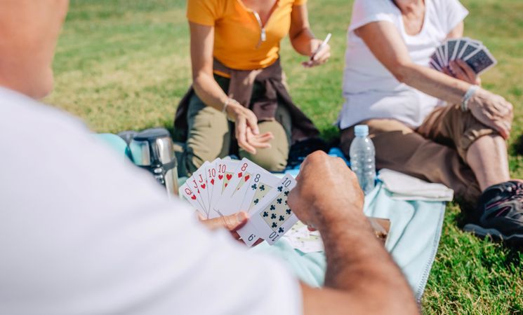 View of man’s playing card over picnic