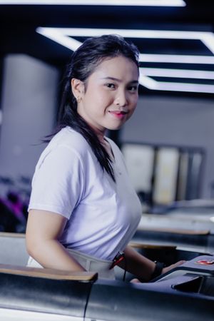 Confident woman exercising on treadmill at modern fitness center