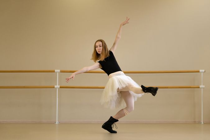 Ballerina in shoes and tutu, extending arm