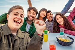 Diverse friends celebrating together at seaside cafe, enjoying outdoor fun