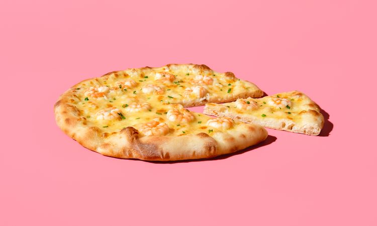 Sliced shrimp pizza minimalist on a vibrant pink table