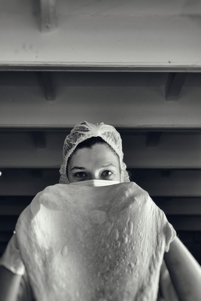 Person wearing hairnet making a dough
