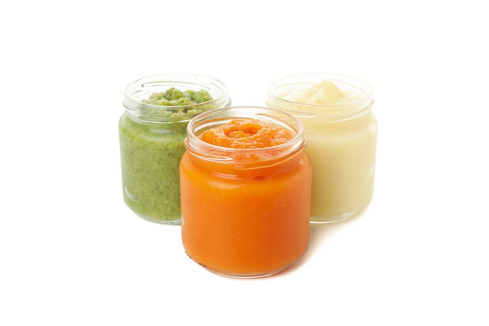 Glass jars with healthy baby food isolated on plain background