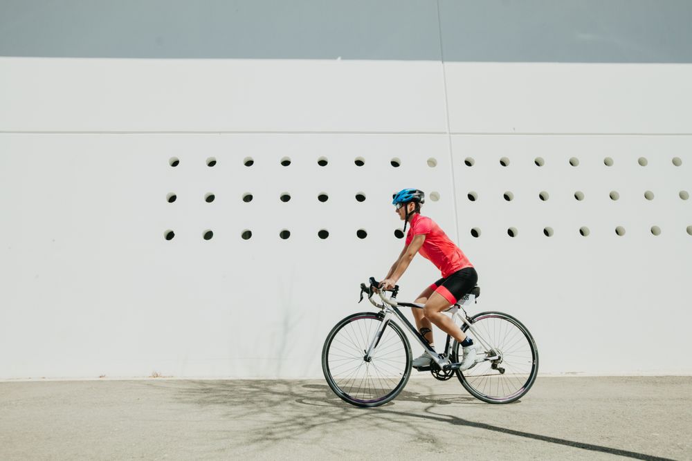 Sportswoman riding bicycle on street