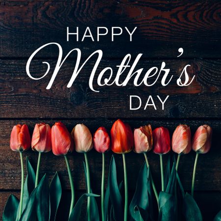 Arrangement of tulips on wooden background with “Happy Mothers Day” text