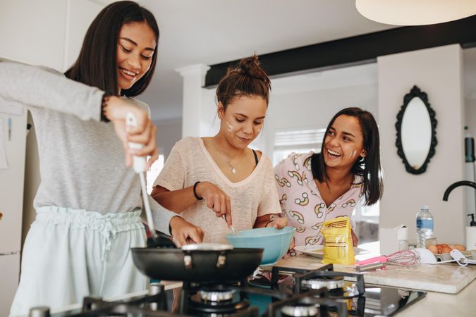 Teenagers preparing breakfast in kitchen