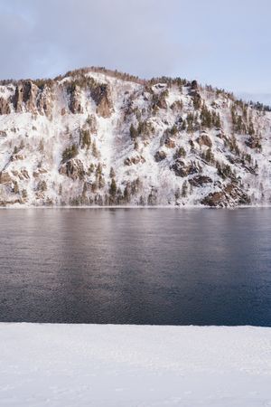 Wide Siberian river and snowy mountains