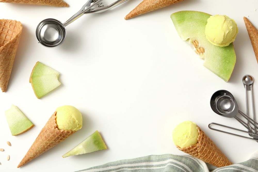 Ice cream cones with pieces of fresh melon on a plain background