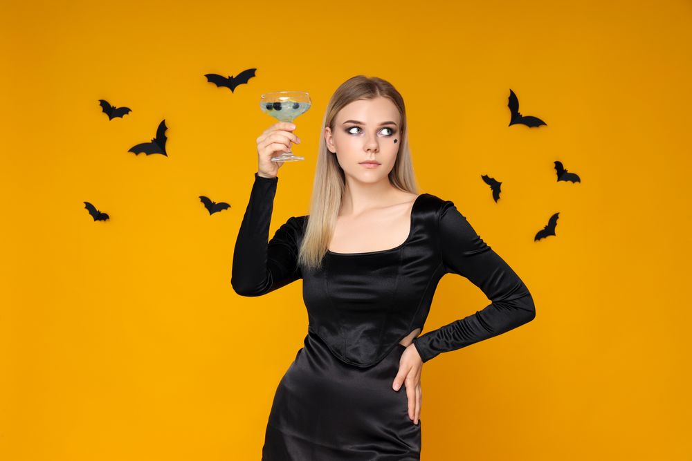 Concept of Halloween, young woman on yellow background