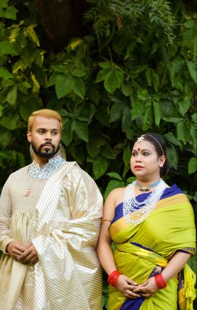 Man and woman in sari standing beside tree