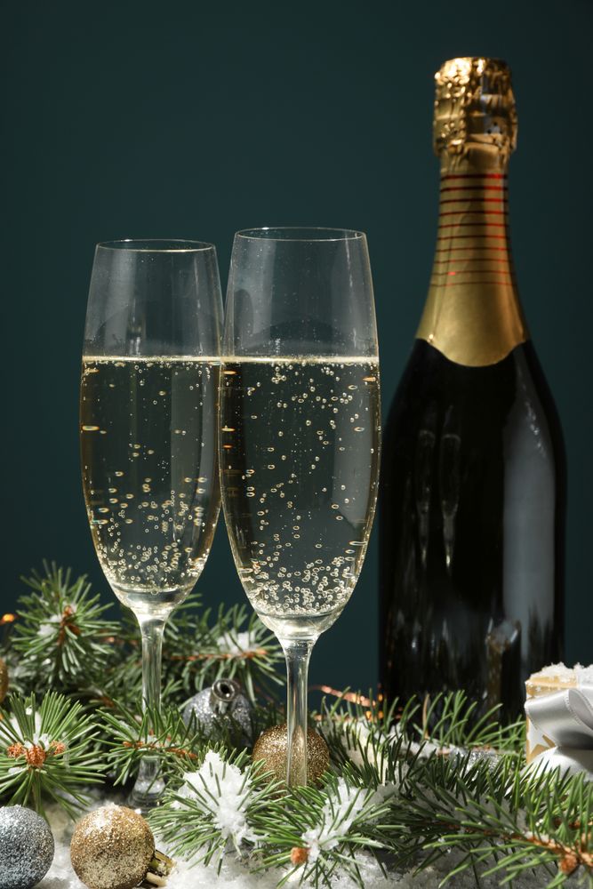 Champagne glasses and bottle on decorated background, close up