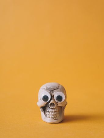 Halloween skeleton head with  googly eyes and orange background