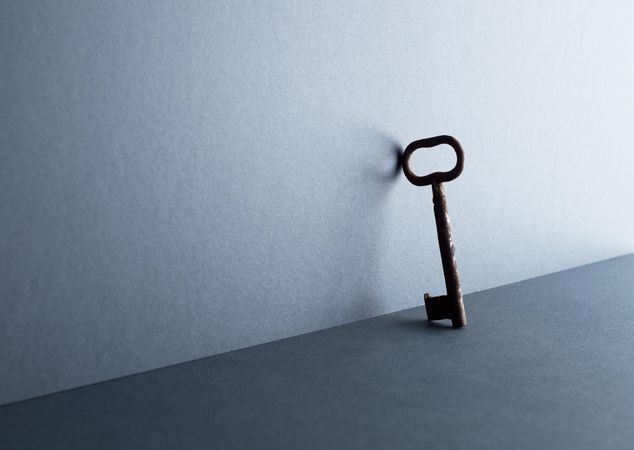 Vintage key leaning against the dark blue background
