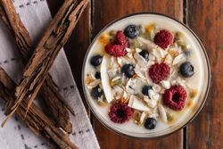 Yogurt in glass bowl with berries and cinnamon sticks
