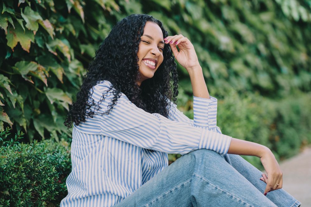 A Joyful Young Woman with Beautiful Curly Hair Enjoying Nature in the Great Outdoors