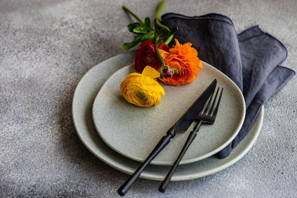 Rustic table setting with buttercup flowers on grey plate