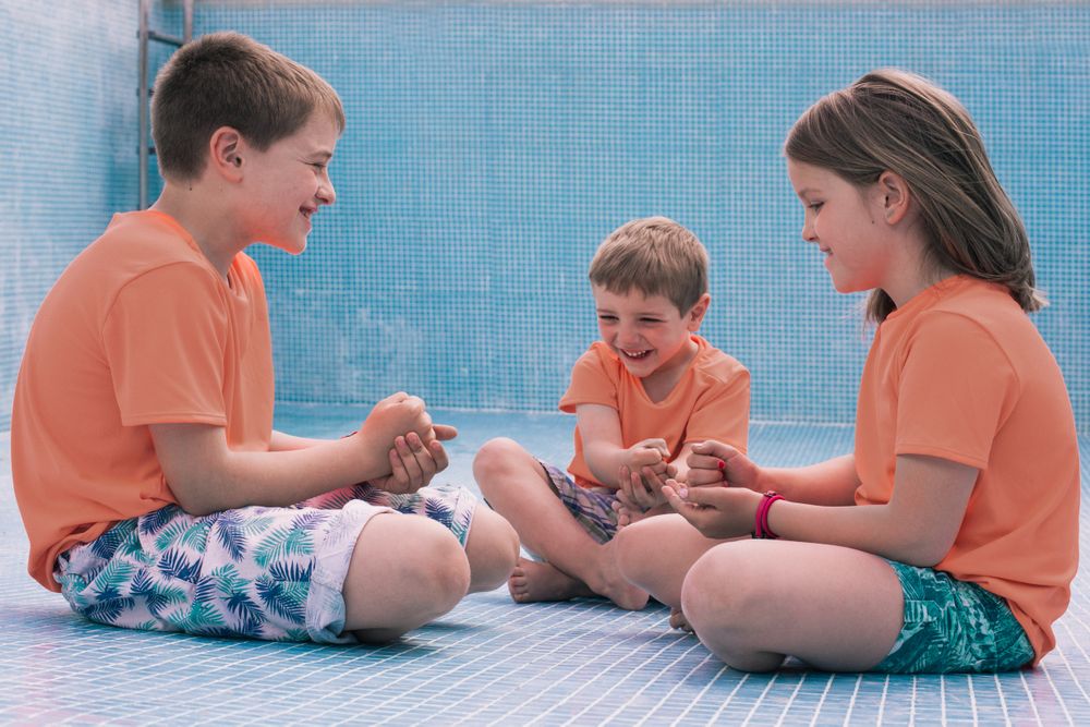 Children playing rock-paper-scissors in empty pool