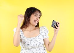 Excited Indonesian Asian Woman Celebrating with Mobile Phone