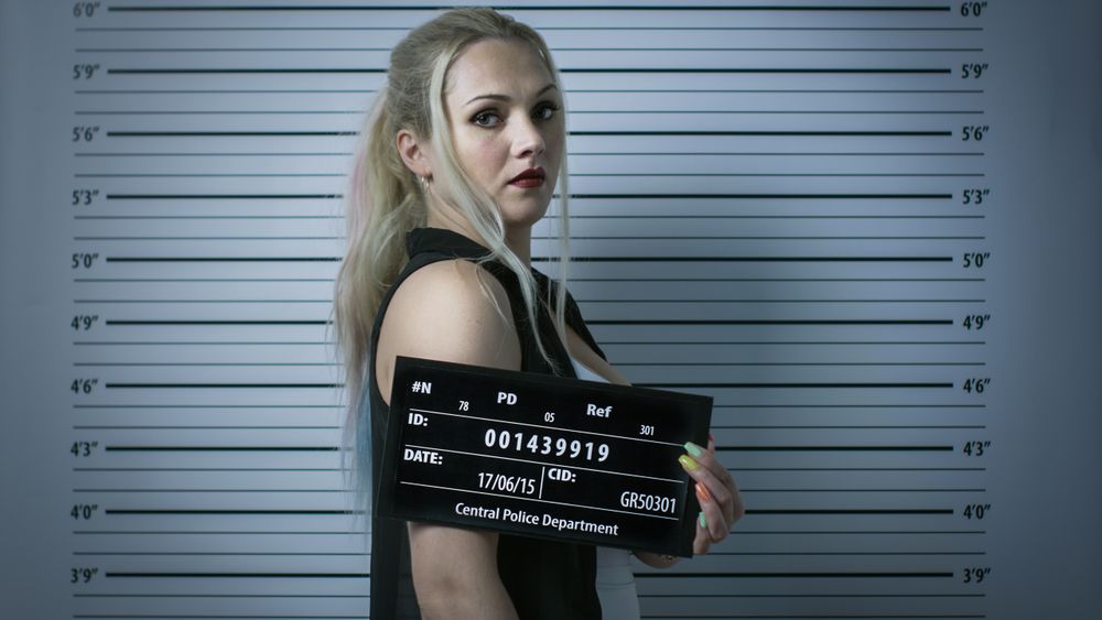 In a Police Station Arrested Woman Gets Side-View Mug Shot.