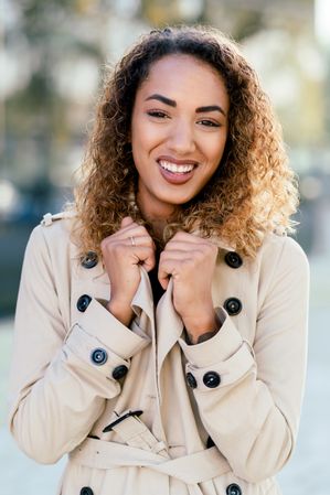 Happy woman with curly hair on street
