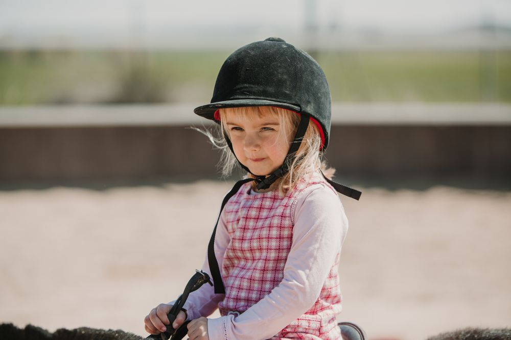 Little girl riding horse on hippodrome