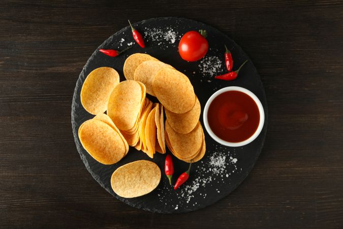 Potato chips in a bowl with chili pepper and sauce