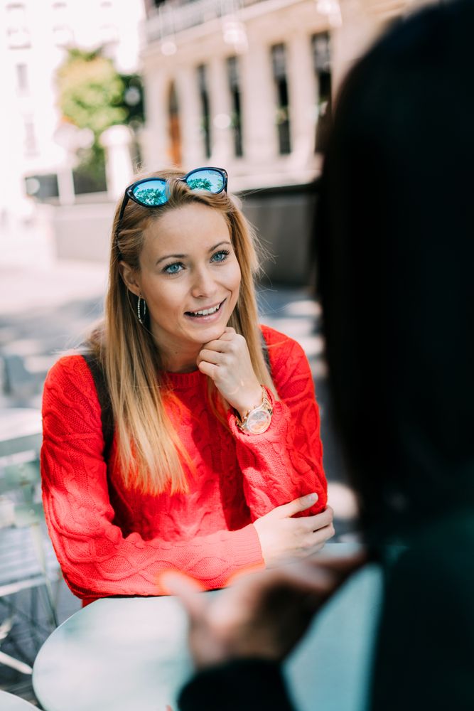 Young woman looking at friend in cafe