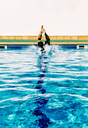 a man enters the pool in a sunny day