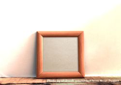 Plain square wooden picture frame leaning against wall mockup 0Vn9G0